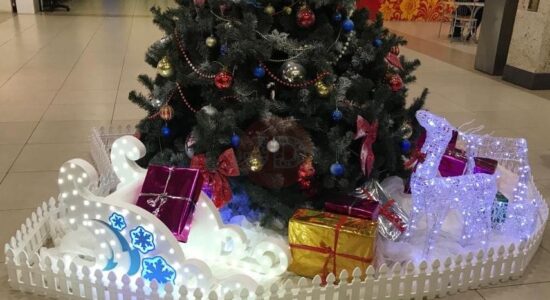 Новогодние сани, олень и подарки под новогодней елкой